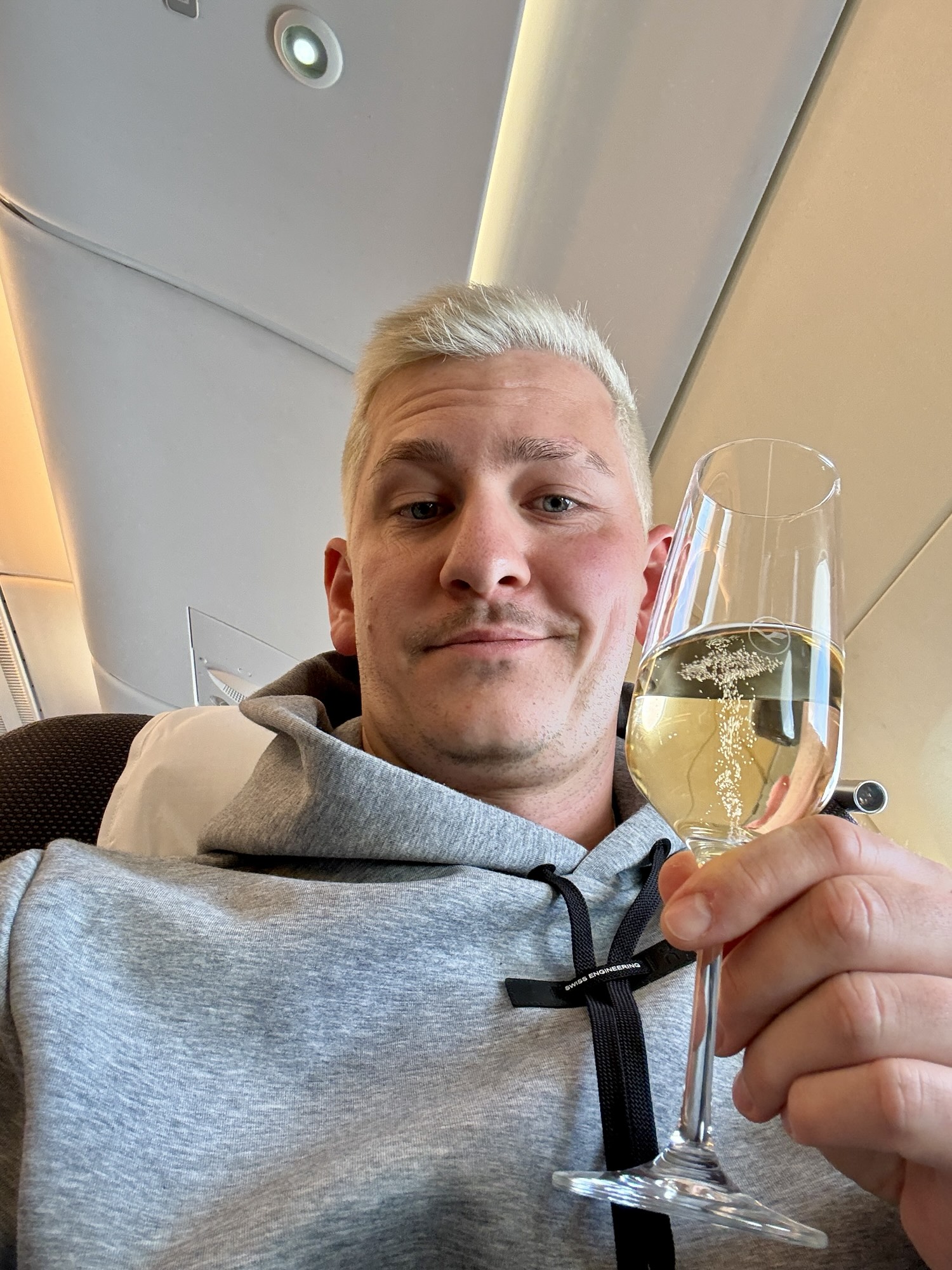 Mit einem Glas Champagner im Flieger